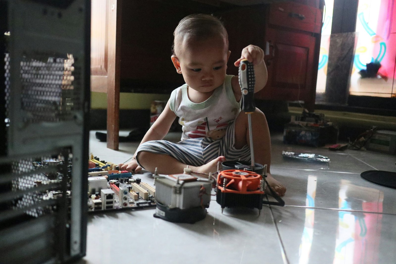 a little boy sitting on the floor playing with a toy